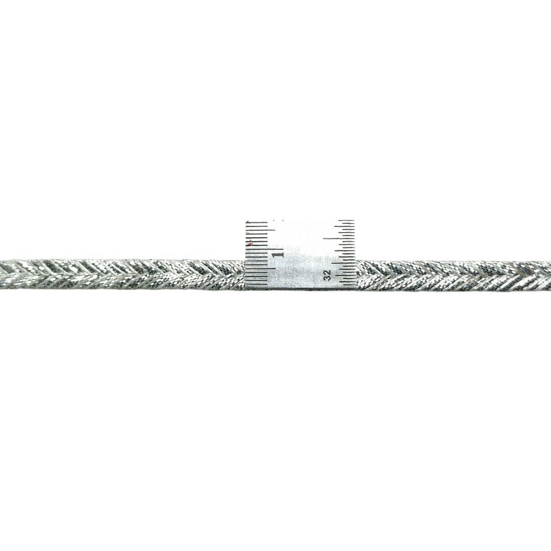 Close-up of a metal cable with a scale on a white background